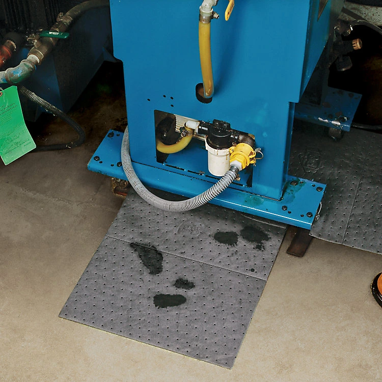 Absorbent pads placed under machinery to capture drips and prevent workshop spills