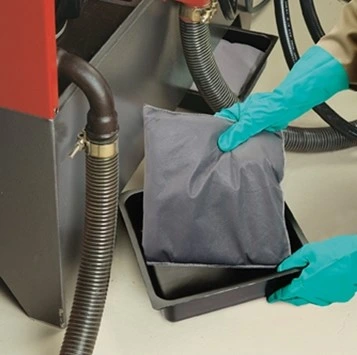 Absorbent pillow positioned under leaking machinery to capture drips and contain liquid safely