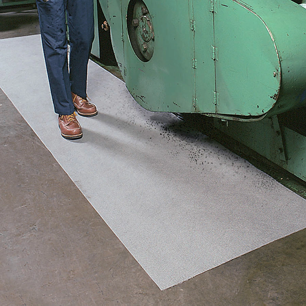 Absorbent roll soaking up a spill on a workshop floor